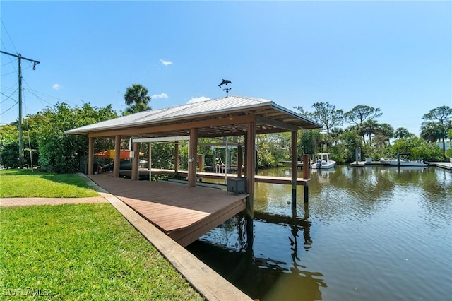 dock area with a lawn and a water view