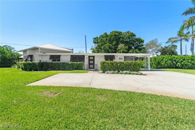 view of front of house featuring a front yard, concrete driveway, and stucco siding