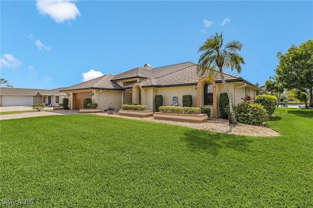 view of front of property featuring a front lawn, a tiled roof, concrete driveway, stucco siding, and a garage