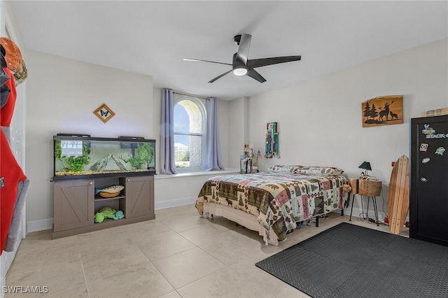 bedroom with tile patterned floors, baseboards, and a ceiling fan