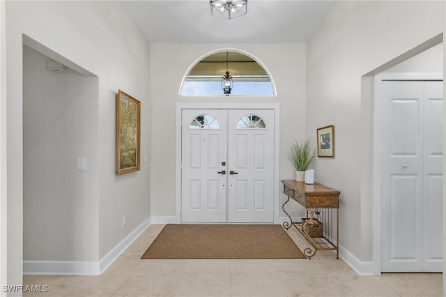 entrance foyer featuring light tile patterned flooring and baseboards