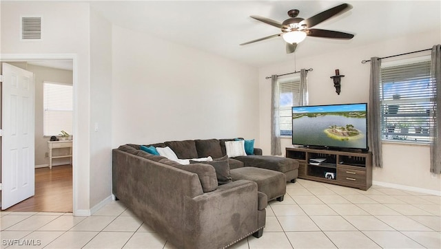living room with light tile patterned floors, baseboards, ceiling fan, and visible vents