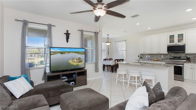 living area featuring light tile patterned floors, visible vents, recessed lighting, and ceiling fan