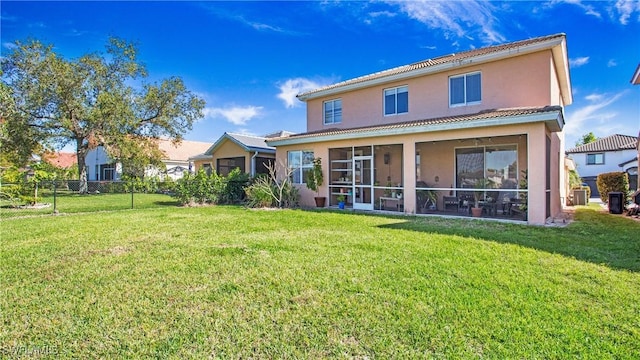 rear view of property featuring a yard, fence, and a sunroom