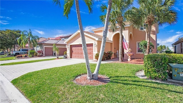 view of front of house with stucco siding, a front yard, an attached garage, and driveway