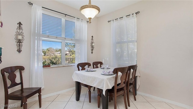 dining space featuring light tile patterned floors and baseboards