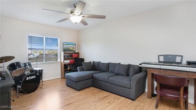 office area featuring baseboards, light wood-type flooring, and ceiling fan