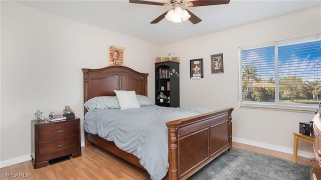 bedroom with baseboards, light wood finished floors, and ceiling fan