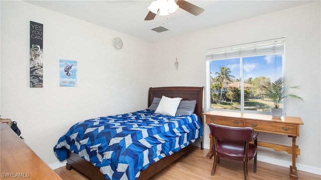 bedroom featuring baseboards, visible vents, and wood finished floors