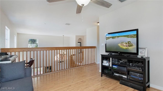 living area with baseboards, visible vents, wood finished floors, and a ceiling fan