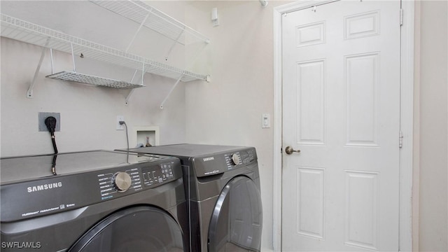 clothes washing area featuring separate washer and dryer and laundry area