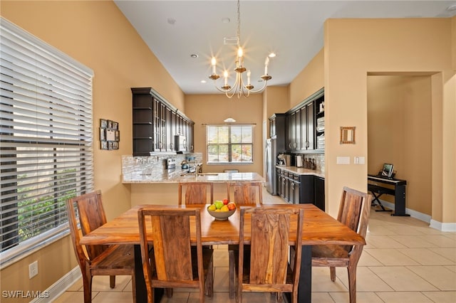 dining room with light tile patterned floors, baseboards, and a notable chandelier