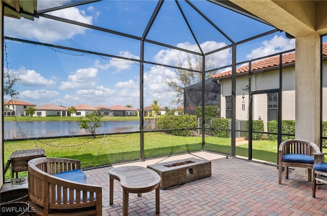 sunroom / solarium featuring a water view and a residential view