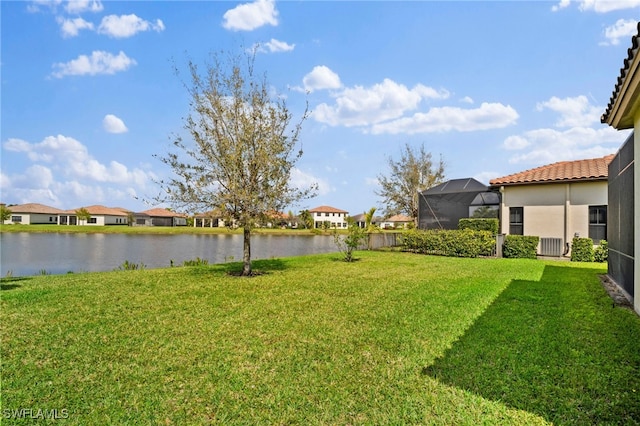 view of yard featuring a water view, glass enclosure, and a residential view