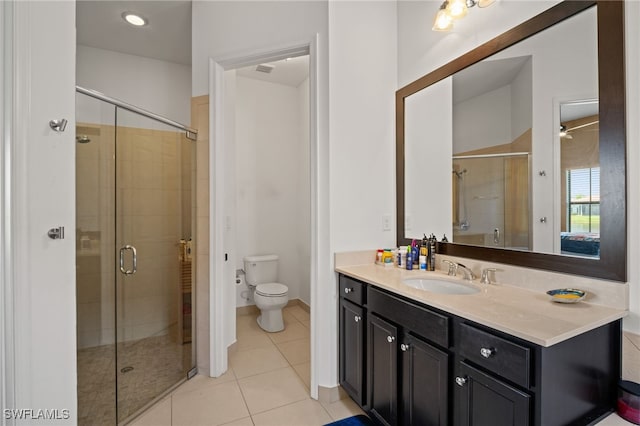 full bathroom with a stall shower, vanity, toilet, and tile patterned floors