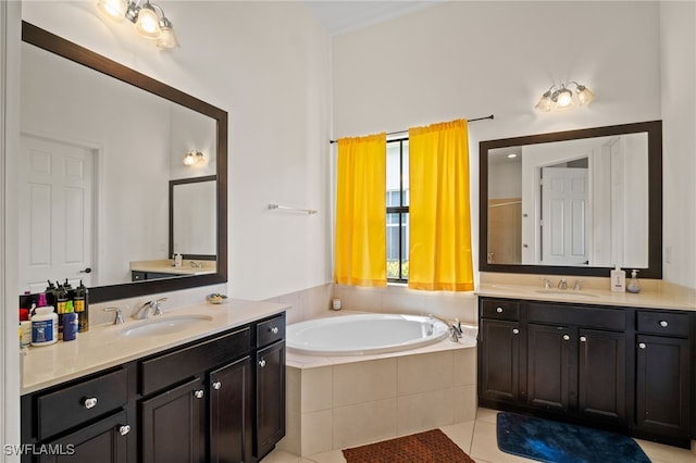 full bath with a garden tub, two vanities, tile patterned flooring, and a sink