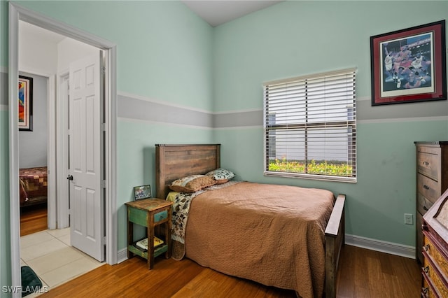 bedroom featuring baseboards and wood finished floors