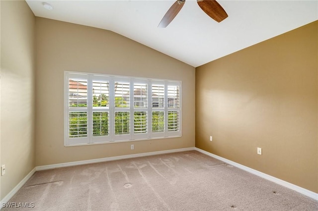 empty room with baseboards, light carpet, a ceiling fan, and vaulted ceiling