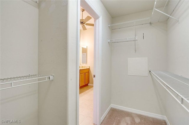 walk in closet featuring light colored carpet and ceiling fan