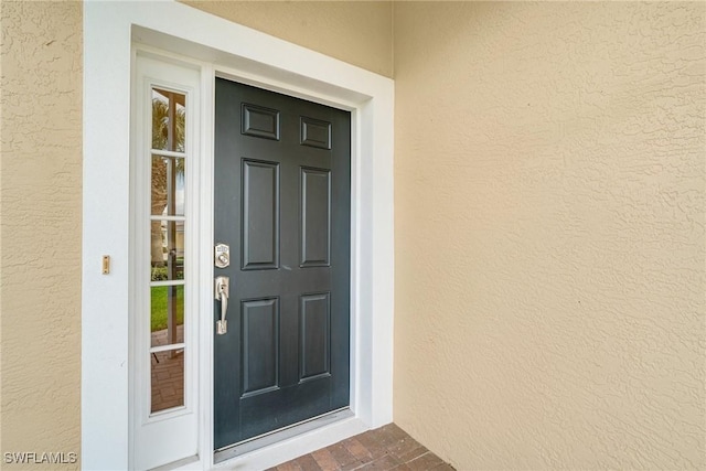 view of exterior entry with stucco siding