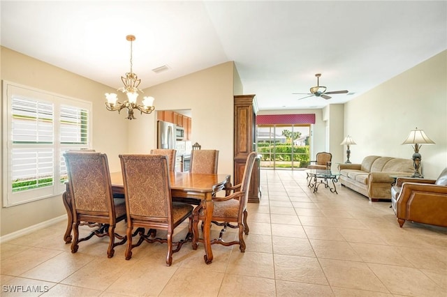 dining space with light tile patterned floors, visible vents, ceiling fan with notable chandelier, and vaulted ceiling