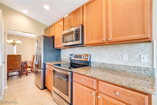 kitchen featuring light stone counters, tasteful backsplash, appliances with stainless steel finishes, light tile patterned flooring, and lofted ceiling