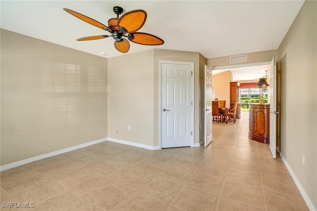 spare room featuring light tile patterned floors, visible vents, ceiling fan, and baseboards