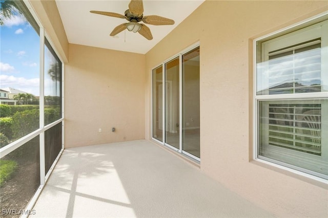 unfurnished sunroom with a ceiling fan