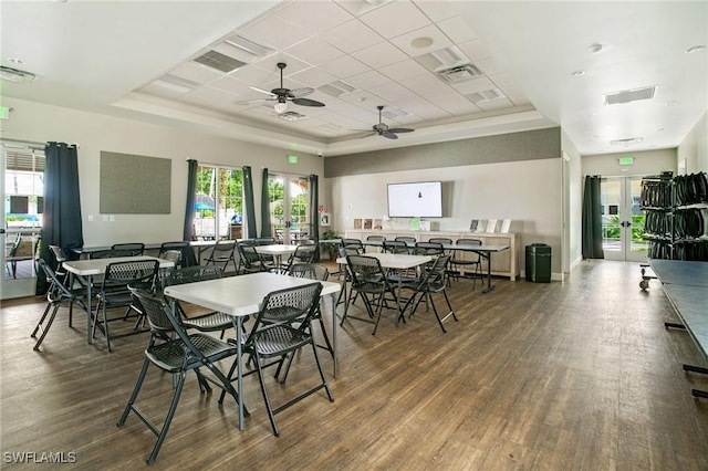 dining room featuring visible vents, a tray ceiling, and wood finished floors