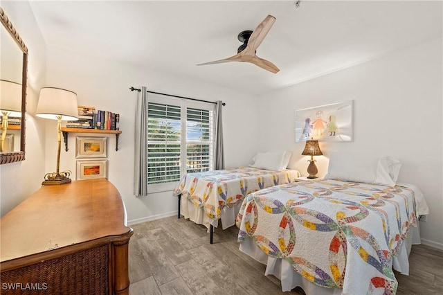 bedroom with baseboards, a ceiling fan, and wood finished floors