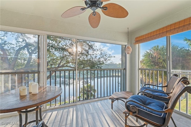 sunroom / solarium featuring a healthy amount of sunlight and a ceiling fan