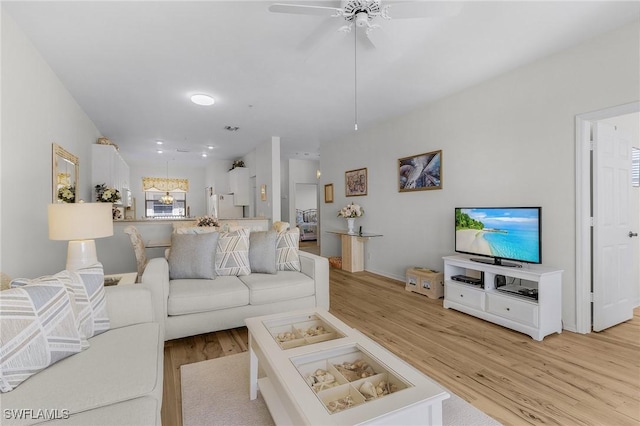 living area with light wood-type flooring and a ceiling fan