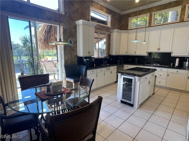 2016 El Dorado Pkwy W, Cape Coral, FL 33914 - kitchen featuring dark countertops, wine cooler, ornamental molding, white cabinets, and a sink