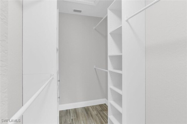 walk in closet featuring visible vents and wood finished floors