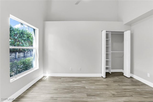 unfurnished bedroom featuring a closet, baseboards, and wood finished floors