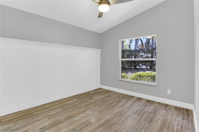 spare room featuring ceiling fan, baseboards, lofted ceiling, and wood finished floors