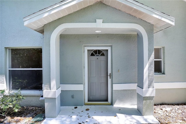 property entrance with stucco siding