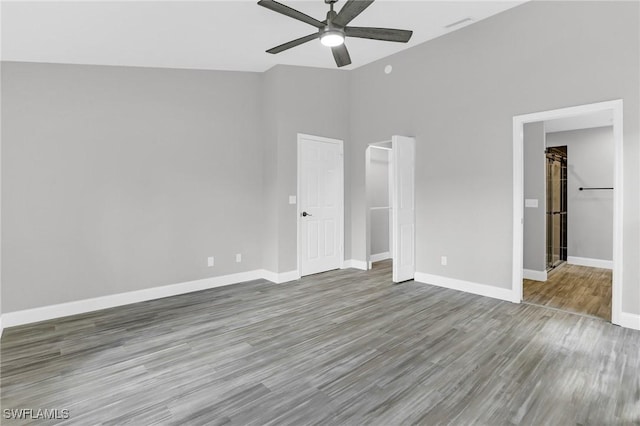 unfurnished bedroom featuring baseboards, wood finished floors, and a ceiling fan