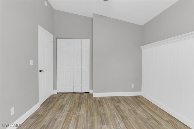 unfurnished bedroom with a closet, baseboards, and wood finished floors