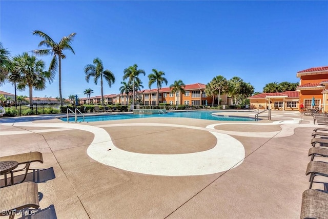 community pool featuring a patio and fence