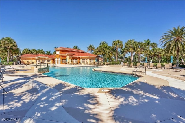 community pool with a patio and fence