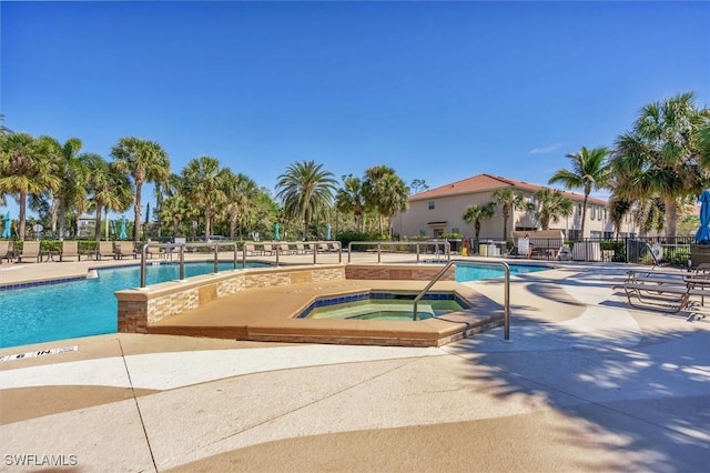 community pool with a patio, a community hot tub, and fence