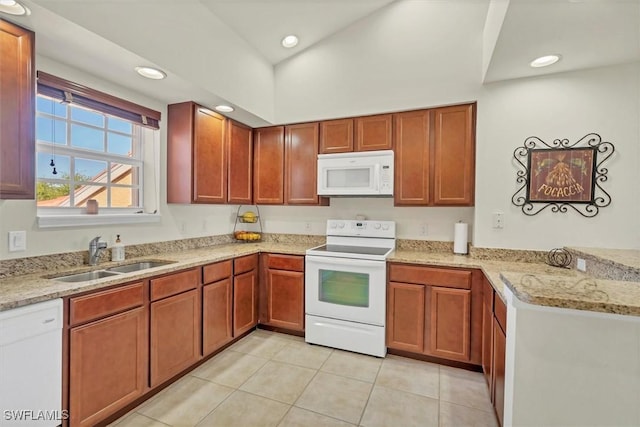 kitchen featuring a sink, white appliances, light tile patterned floors, lofted ceiling, and light stone countertops