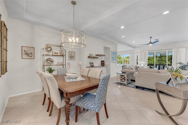 dining area featuring light tile patterned flooring, recessed lighting, a raised ceiling, and baseboards