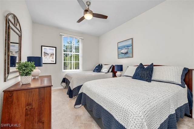 bedroom featuring baseboards, light colored carpet, and ceiling fan