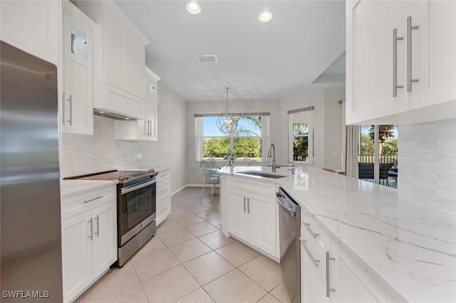 kitchen featuring visible vents, a sink, white cabinetry, stainless steel appliances, and decorative backsplash