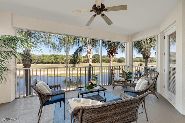 sunroom / solarium featuring a water view and a ceiling fan