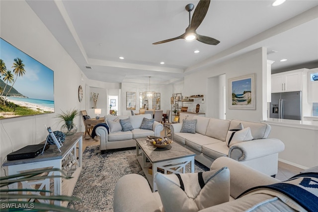 living area with recessed lighting, a tray ceiling, a ceiling fan, and light tile patterned floors