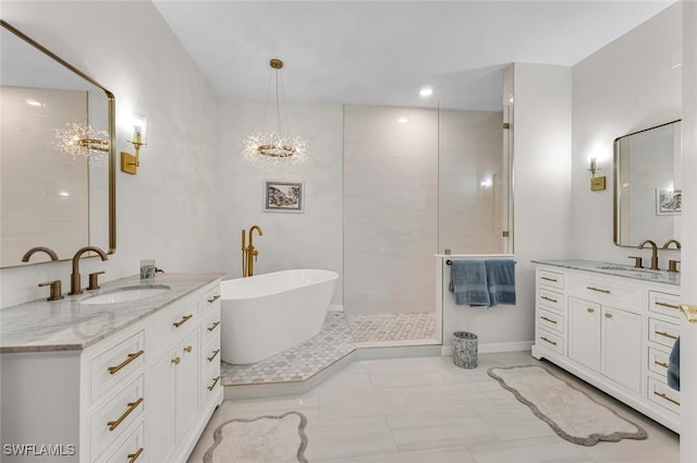 full bathroom featuring a sink, a freestanding bath, and two vanities