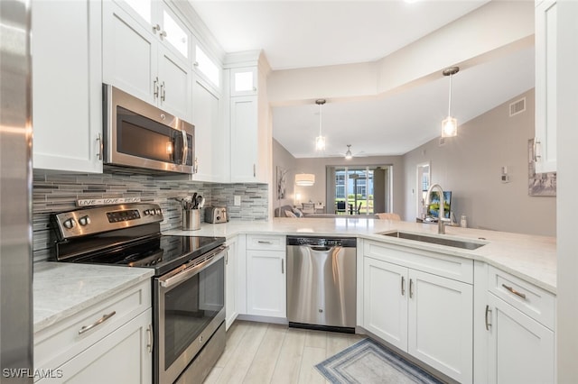 886 Tanbark Dr SW Unit 103, Naples, FL 34108 - kitchen featuring stainless steel appliances, a sink, tasteful backsplash, light stone countertops, and a peninsula
